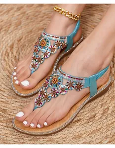 Close-up of bohemian blue sandals featuring intricate handmade floral beads and rhinestones