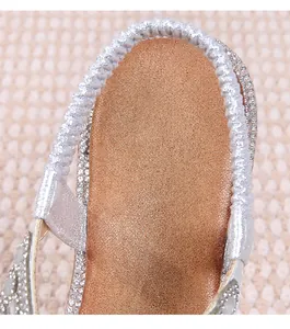 Macro detail of silver elastic heel strap and sparkling rhinestone embellishment on sandals