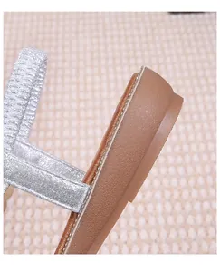 Macro shot of bohemian silver glitter straps and brown non-slip rubber sole detail