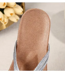 Macro shot of silver woven braided straps and champagne non-slip sole on women sandals