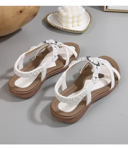 Détail de sandales bohèmes blanches avec fleurs délicates et bride élastique au talon