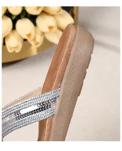 Macro detail of silver sequined straps and slip-resistant sole on women's summer sandals