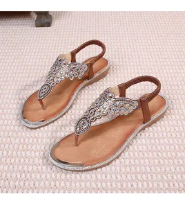 Detail of bohemian flat sandals featuring intricate butterfly rhinestone patterns on T-straps