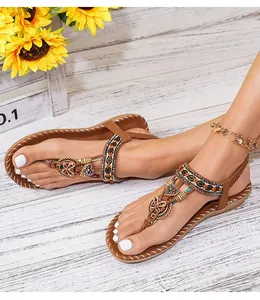 Detail van bohemien platte sandalen met gekleurde kralen en vlinderbedeltjes