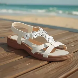 Sandali bohémien bianchi con cinturino a T e fiori su un ponte di legno al mare