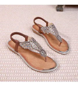 Detail of bohemian flat sandals with sparkling rhinestones and elastic heel strap