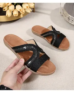 Detail of black woven strap sandals with sequins and soft brown cushioned footbed
