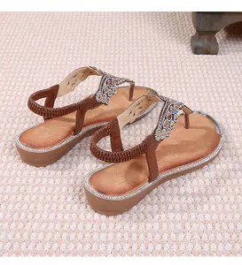 Detail of warm brown bohemian flat sandals with sparkling rhinestones and elastic strap