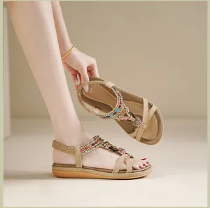 Détail de sandales plates bohèmes avec perles colorées, breloques cœur et brides tressées