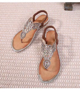 Detail of bohemian flat sandals with sparkling rhinestones and elastic heel straps