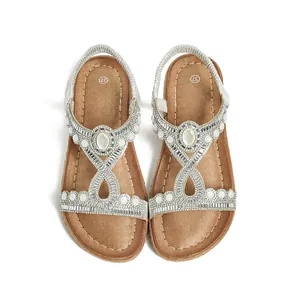 Détail de sandales plates bohèmes avec des strass étincelants et des perles blanches