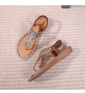 Detail of bohemian flat sandals featuring intricate rhinestone beadwork and elastic back straps