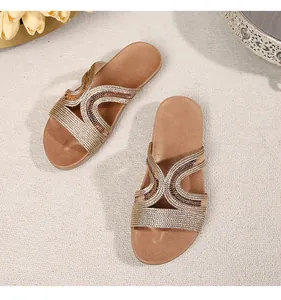 Macro view of woven champagne gold slippers with sparkling rhinestones and textures