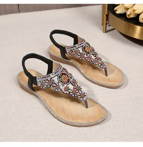 Detail of bohemian wedge sandals featuring colorful rhinestone flower patterns and t-strap design