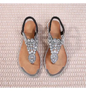 Close-up of geometric silver rhinestone patterns on bohemian flat sandals with toe straps