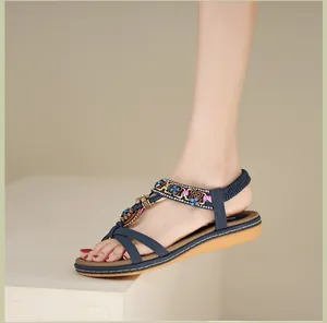 Details von böhmischen flachen Sandalen mit blauen Blumenperlen und Glitzersteinen