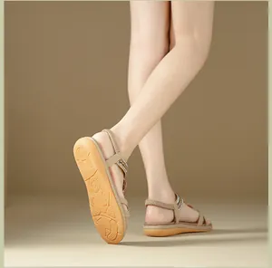 Detailed macro view of beige flat sandals showing non-slip sole and rhinestone straps