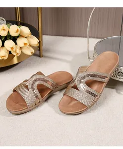 Detail of champagne gold flat sandals with sparkling sequins on woven cross straps