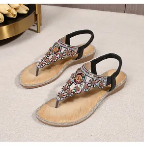 Detail of bohemian sandals with colorful rhinestones and beaded flower on a T-strap