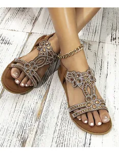 Dettaglio macro di sandali boho con strass marroni e pietre preziose d'ambra