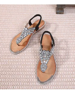 Close-up of bohemian flat sandals with sparkling rhinestones and elastic heel strap