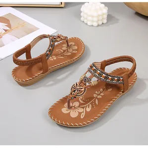Detail van boho-sandalen met kleurrijke kralen en metalen vlinderbedeltjes