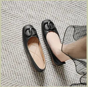 Detail van zwarte lederen loafers met ruitvormig gewatteerde zolen en metalen gesp dames