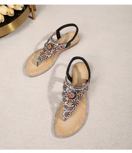 Detail of bohemian T-strap sandals with colorful beads, rhinestones and latex sole