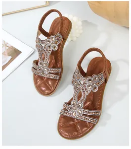 Λεπτομέρεια από φλατ σανδάλια boho με λαμπερά στρας λουλούδια και σχέδιο με λουράκι T