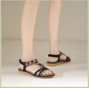 Detail von böhmischen flachen Sandalen mit bunten Perlen, Blumen und Gummizug