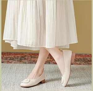 Chique beige ballerina's met vierkante neus en lage houten blokhak op tapijt