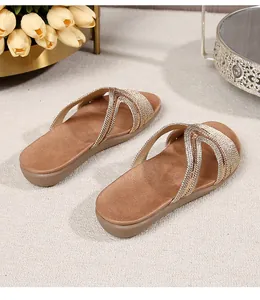 Detailed close-up of golden crisscross straps with metallic texture on flat sandals
