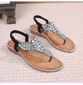 Close-up of bohemian flat sandals featuring sparkling rhinestones and elastic heel straps