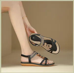 Detail of bohemian flat sandal showing elastic back strap and gold heart rhinestone charm