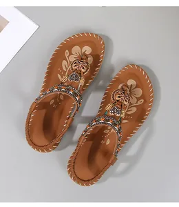Detail van bohemian platte sandalen met kleurrijke kralen, pailletten en bedeltjes