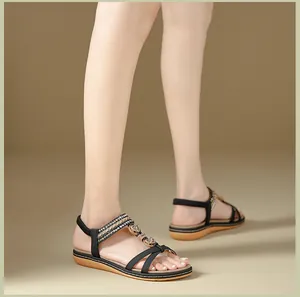 Detail view of black summer sandals with rhinestone straps and gold heart accents
