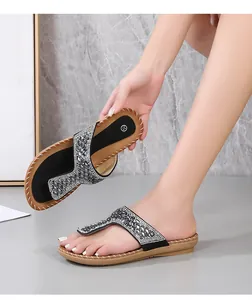 Vista detallada de chanclas bohemias con diamantes de imitación y bordes de suela cosidos