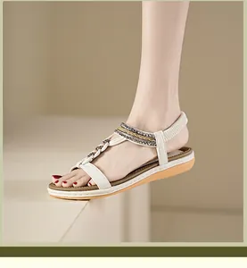 Detail von Boho-Flachsandalen mit Perlen-T-Riemen und elastischem Fersenriemen