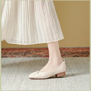 Detail van beige instappers met ronde neus van zacht leer en een comfortabele lage blokhak