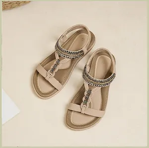 Detailansicht beige flache Sandalen mit Strass-T-Riemen und elastischem Fersenband