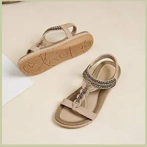 Details flacher beiger Sandalen mit elastischen Riemen, Webstruktur und rutschfester Sohle