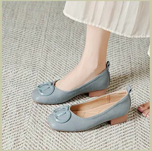 Detail van grijsblauwe loafers met zachte zool, gespdecoratie en lage blokhak