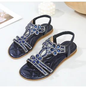 Λεπτομέρεια από boho σανδάλια με μπλε στρας λουλούδια και ελαστικό λουράκι στη φτέρνα