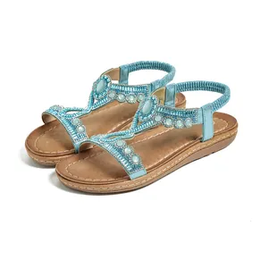 Détail de sandales bohèmes bleues avec des perles et des ornements de pierres précieuses