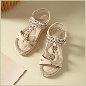 Detail of beige flat sandals with heart metallic ornaments and sparkling rhinestones