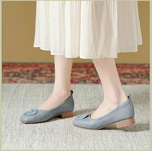 Detail van grijsblauwe leren loafers met ronde neus en gesp aan een model