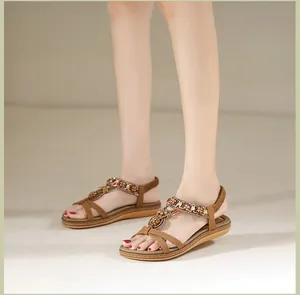 Draufsicht auf böhmische braune T-Riemen-Sandalen mit Ethno-Perlen und Metalldekor