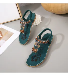 Detail van bohemian platte sandalen met kralen, smaragdgroene bandjes en bloemen binnenzolen