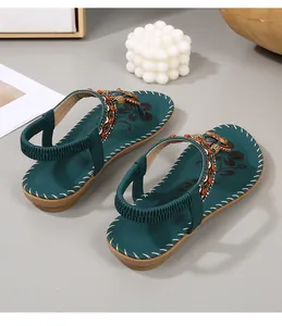 Detail van groenblauwe boho-sandalen met etnische kralen en bloemenprint voetbed