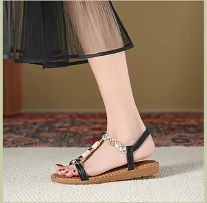 Detail von flachen Damensandalen mit T-Riemen-Design und Schnalle in Marmoroptik